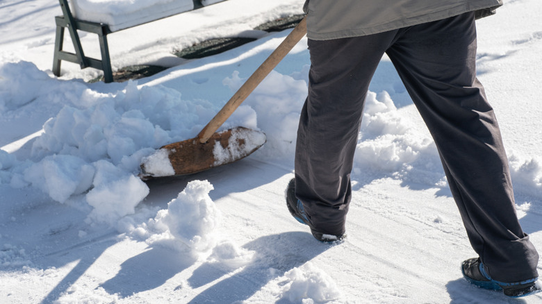 Man clearing snow off of driveway with shovel