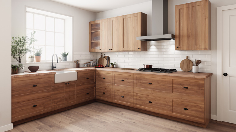 A modern farmhouse kitchen with wooden cabinets and black handles