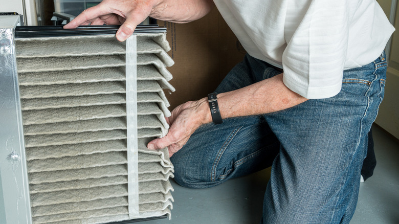 Man taking out dirty HVAC filter