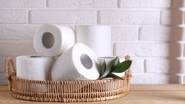 Rolls of toilet paper in a wicker basket.