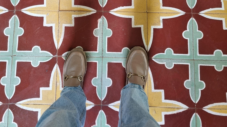 Person standing on floor tiles with colorful patterns