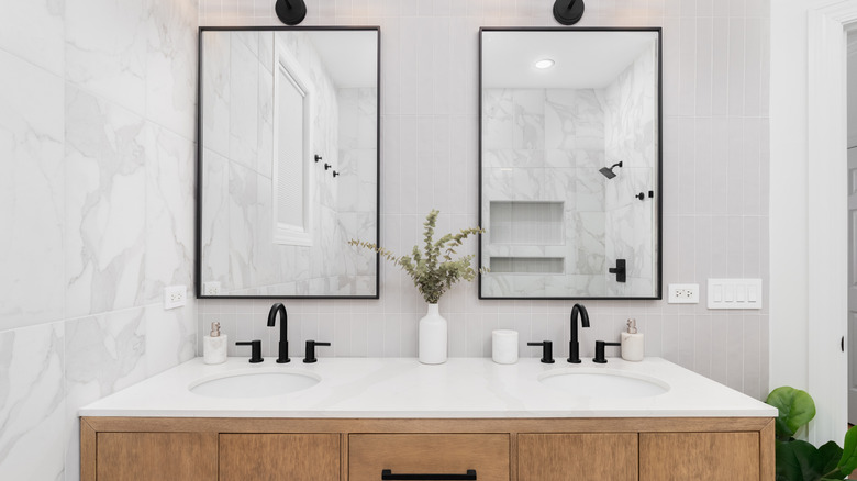 A wooden bathroom vanity and sink with a white quartz countertop