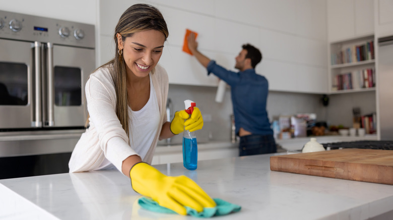 Woman clean countertops with Windex