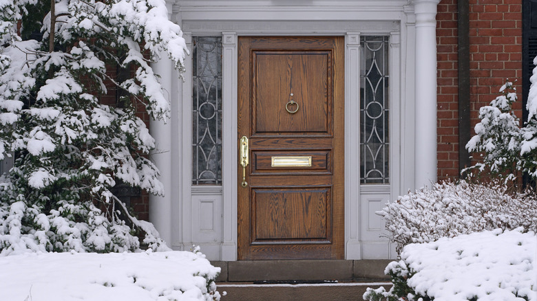 Front door surrounded by snow