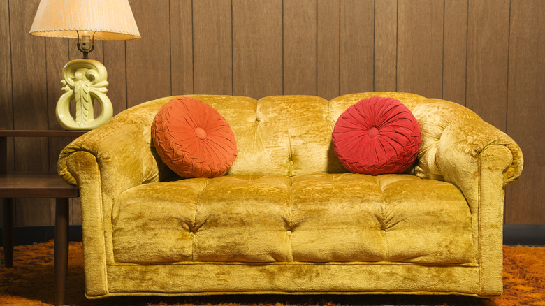 Yellow couch and wood wall
