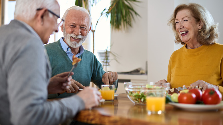 3 seniors enjoying a meal at a dining table