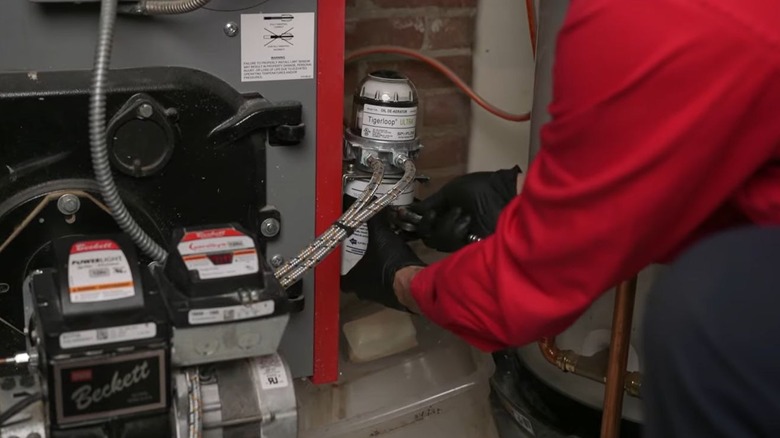 Technician fixing an oil furnace