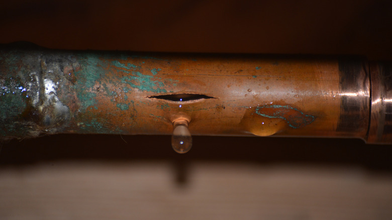 a burst copper water pipe still dripping water