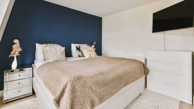 Bedroom with a dark blue accent wall