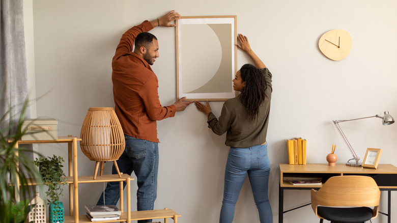 A couple decorating their living room