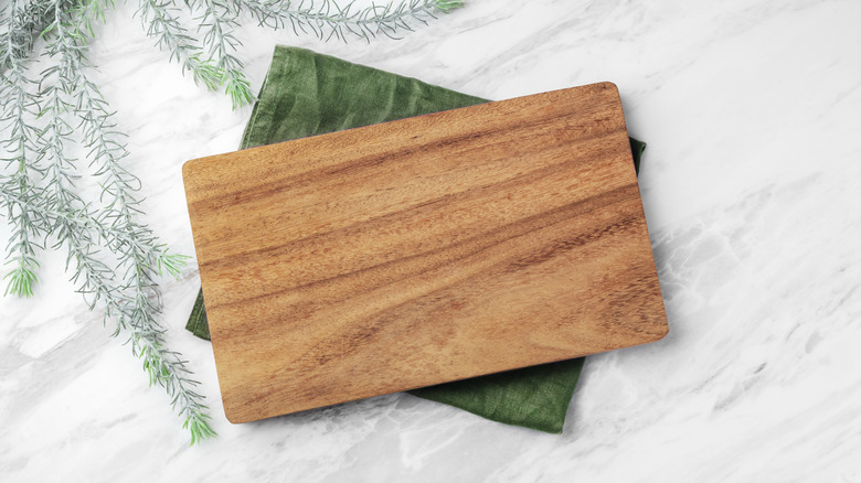 A wooden cutting board on a marble countertop