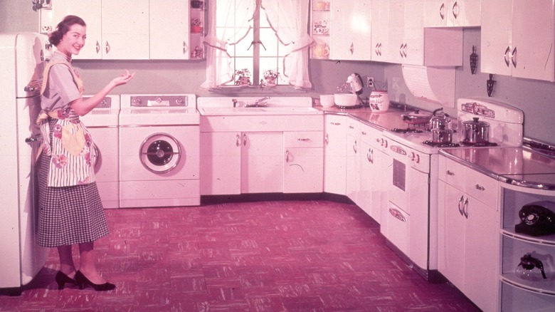Person smiling and pointing while standing in a 1950s kitchen