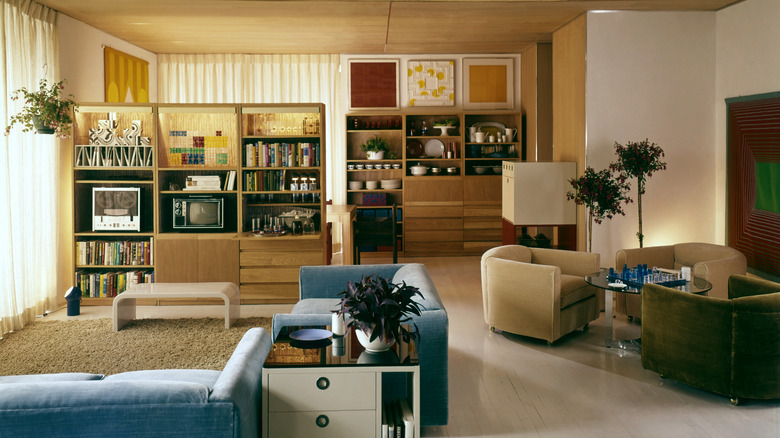 A trendy 1960s living room with wood accents and colorful chairs