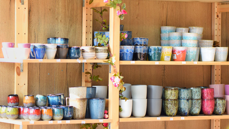 Colorful ceramics stacked on wooden store shelf