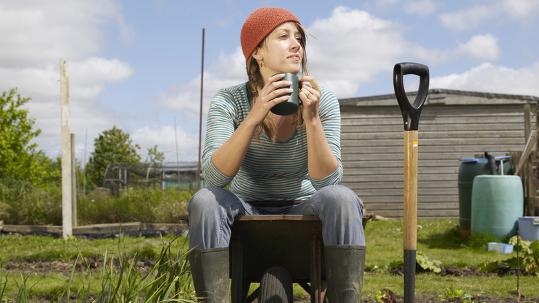 Young woman contemplates her garden.
