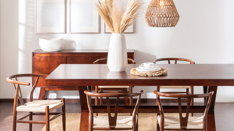 A dining room table surrounded by wishbone chairs.