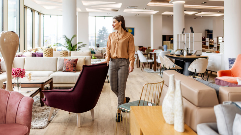 A woman shops for chairs inside of a furniture showroom.