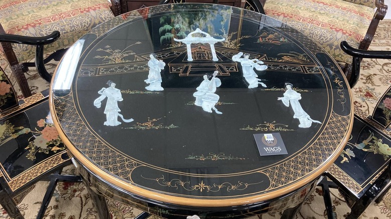 Detailed design on black lacquered Chinoiserie table.