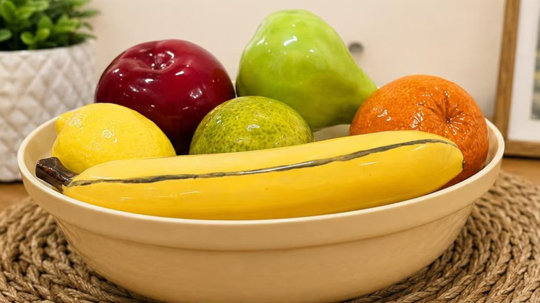 1980s ceramic fruit bowl with banana, citruses, apple, and pear, on a tabletop
