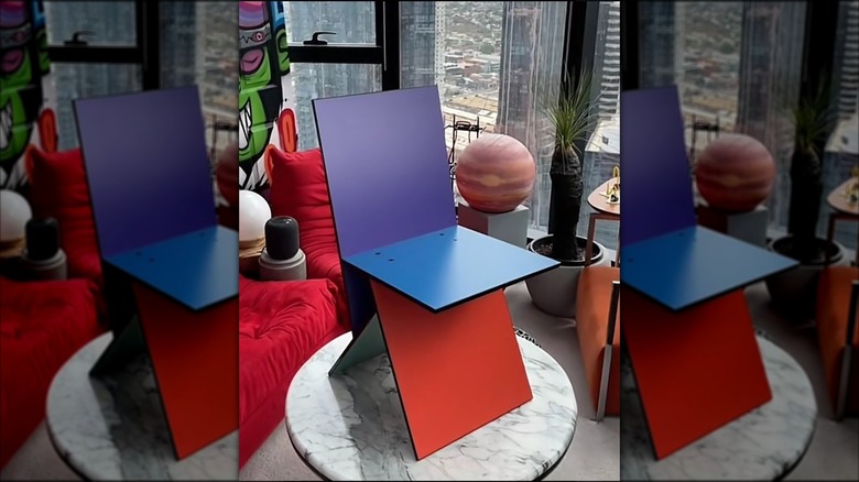 The purple backrest version of the Vilbert chair on top of a white marble table in an apartment.