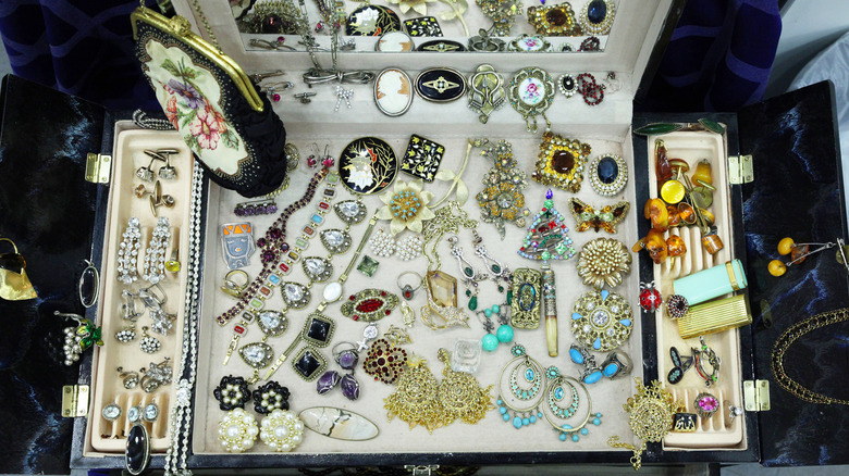 An opened jewelry display case filled with vintage jewelry.