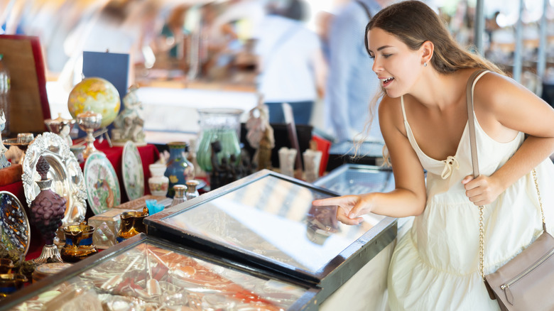 Woman pointing at items on a flea market table