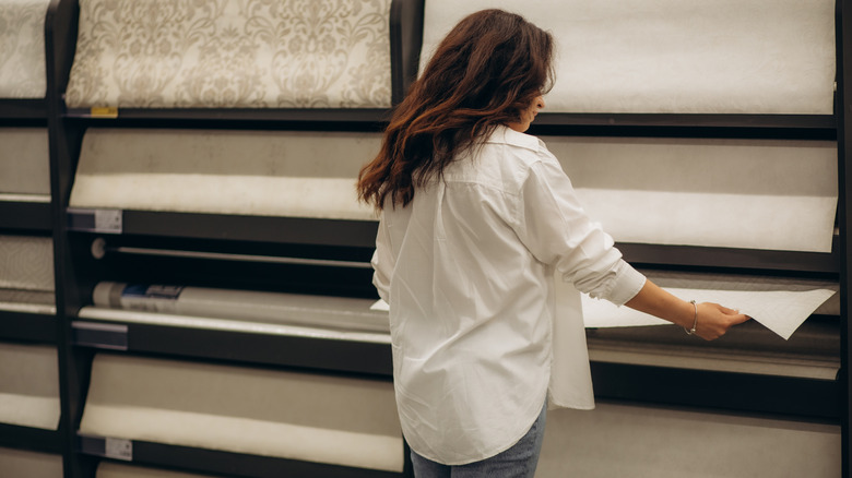 A woman shopping for patterned wallpaper