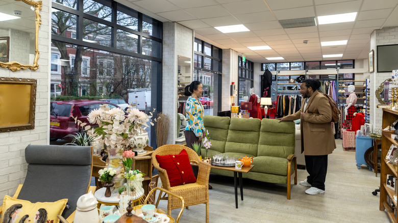 Two people shopping for home goods in a thrift store.