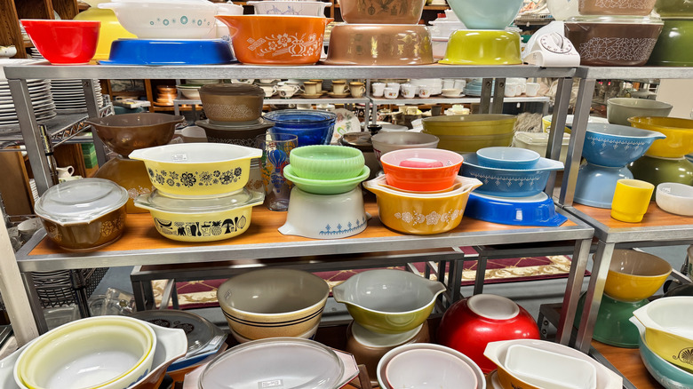 A stack of vintage Pyrex bowls on the shelves of a thrift store.