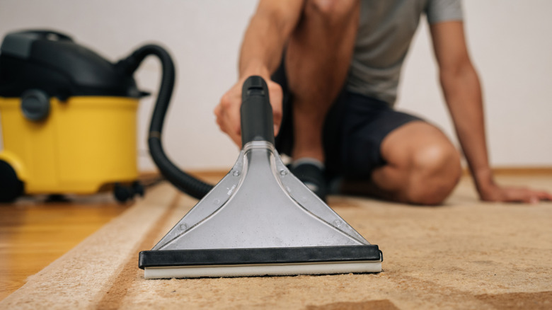 Person using  a small carpet cleaner nozzle