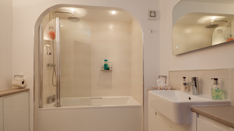An alcove bathtub nestled between the walls with an arch design