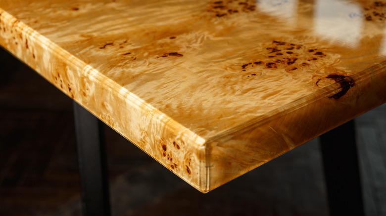 A burl wood table with black legs