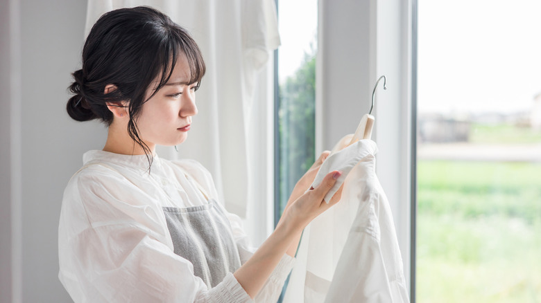 Woman finds stain on the collar of a white shirt.