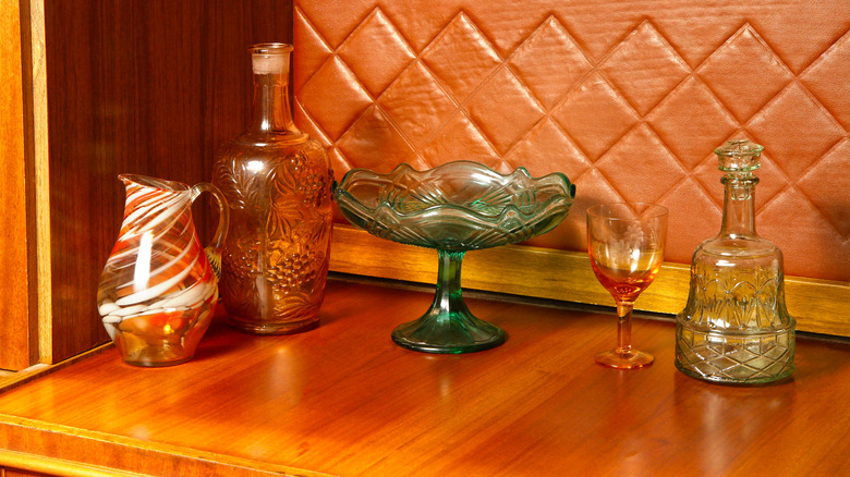 Vintage depression glass styled in a warm toned cabinet.