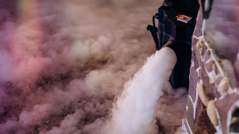 Fog machine dispensing fog across floor