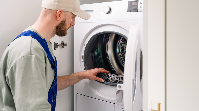 Man inspecting washing machine in home