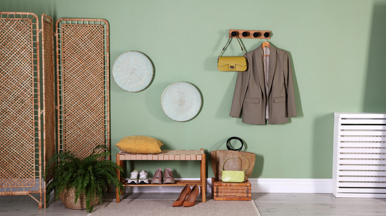 A coat and bags hanging on a wall rack
