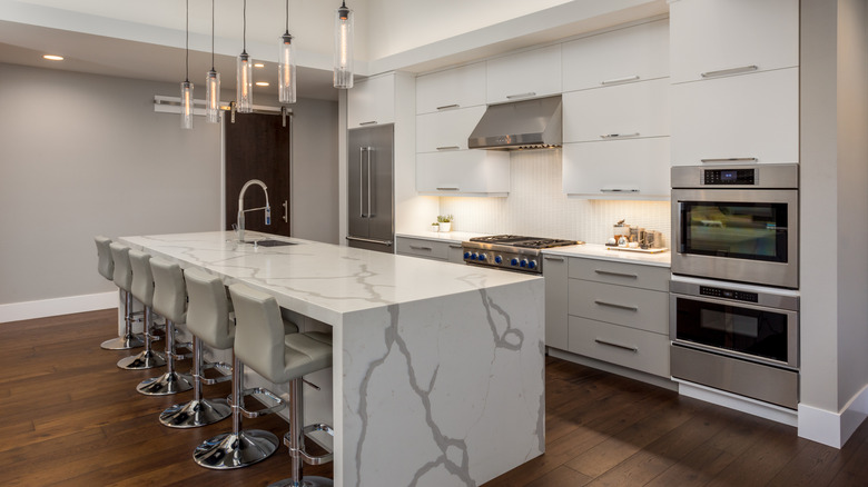 All-white kitchen with waterfall island countertop