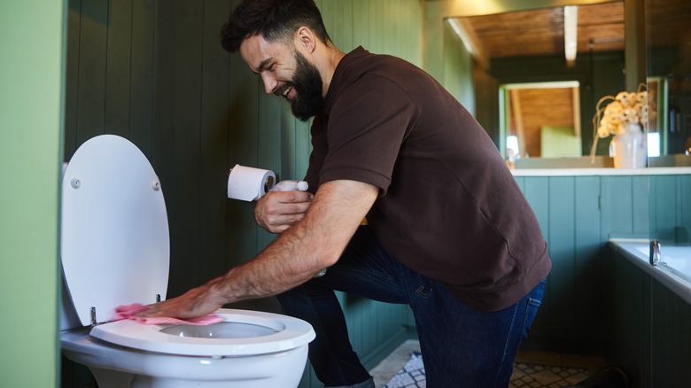 Man cleaning toilet seat