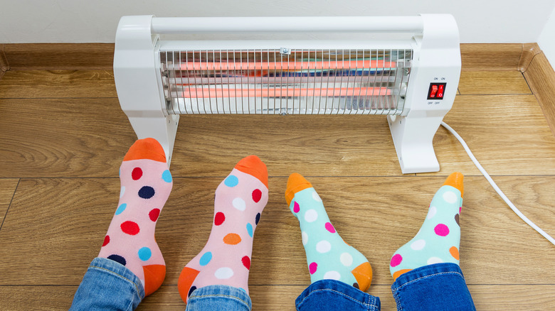 Feet warming up next to an electric space heater