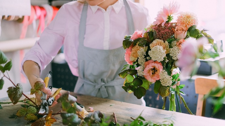 Person works on arranged flowers