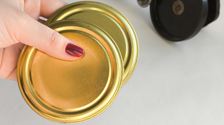 Metal jar lids in a woman's hand