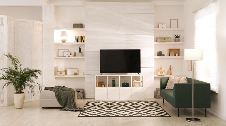 White living room with storage and green couch