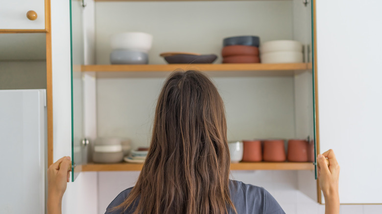 Woman opening the kitchen cabinet