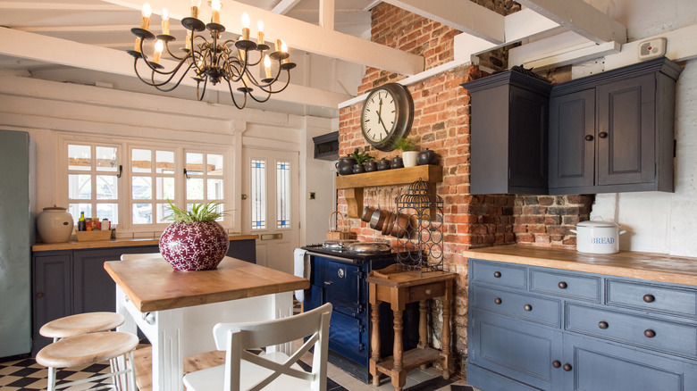 Kitchen with brick wall and cabinets in multiple shades of blue