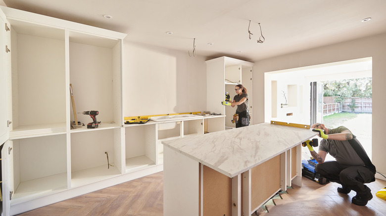 A woman and a man refurbishing kitchen cabinets