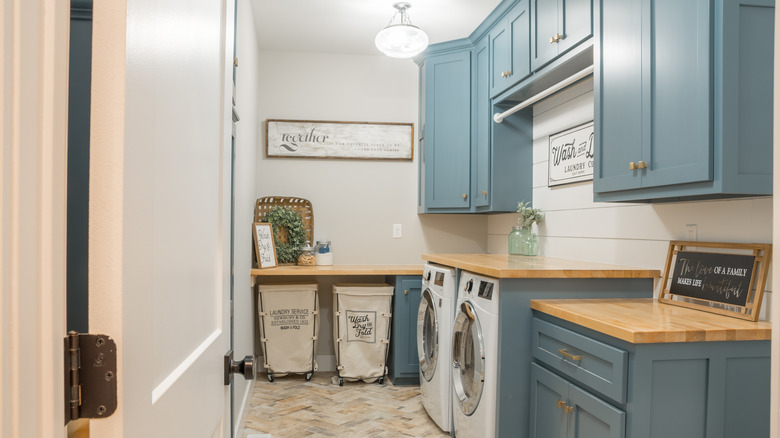 Laundry room with blue cabinets