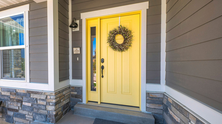 Front porch with a yellow front door.