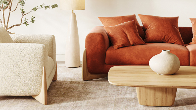 A Scandinavian living room featuring a terracotta sofa paired with a sleek white floor lamp.