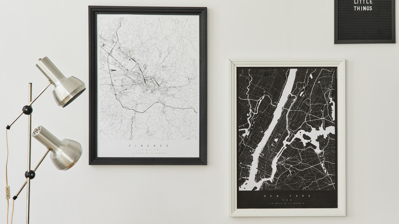 Black and white framed maps hang on a wall